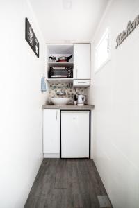 una pequeña cocina con armarios blancos y fregadero en Stunning Studio By The Beach With Free Parking, en Tel Aviv