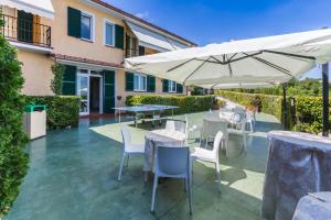 a patio with tables and chairs and an umbrella at Villa La Quiete in Mogliano