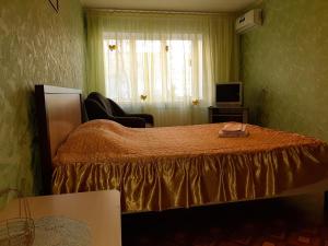 1 dormitorio con 1 cama, TV y ventana en 1 комн.Центр,Ж/Д Вокзал, en Volgograd