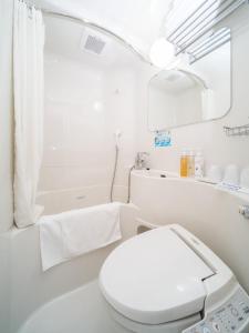 a white bathroom with a toilet and a bath tub at Super Hotel Takamatsu Kin en kan in Takamatsu