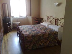 een slaapkamer met een bed met een bloemendeken erop bij Albergo Locanda Garibaldi in Siena