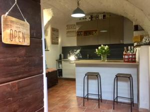 a kitchen with a counter and two bar stools at Residenza Erbaluna in Oggebbio