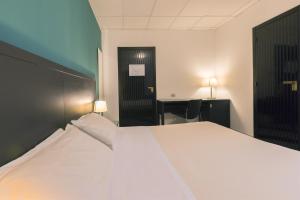a bedroom with a large white bed and a desk at Executive Business Hotel in Bari