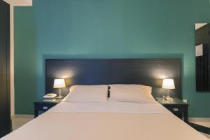 
a hotel room with a bed and two lamps at Best Western Executive Business Hotel in Bari
