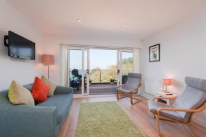 a living room with a couch and two chairs at Avocet 2 at The Cove - Stunning Sea Views, Heated Pool and Parking in Brixham