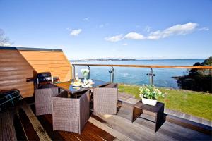 a balcony with a table and chairs and a view of the water at Avocet 2 at The Cove - Stunning Sea Views, Heated Pool and Parking in Brixham