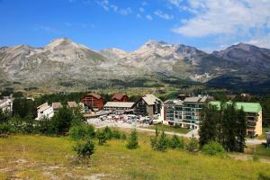 a town in front of a mountain range with mountains at Flocons du Soleil by Actisource in La Joue du Loup