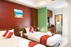 2 letti in una camera con cucina di Samui Honey Suite a Choeng Mon Beach