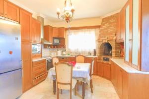 a kitchen with a table and chairs and a kitchen with a refrigerator at Villa Eftihia in Nýmfai