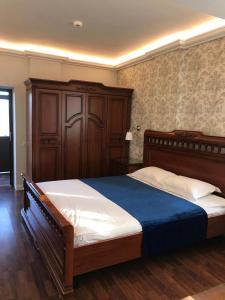 a bedroom with a large bed with a blue blanket at Pension Hanul Andritei in Craiova