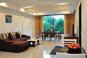 un soggiorno con un divano e un tavolo di Samui Honey Suite a Choeng Mon Beach