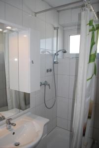 a white bathroom with a shower and a sink at Hotel Lohmann in Münster