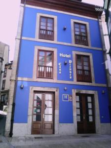 a blue building with doors and windows on a street at Hotel Casa Prendes in Cudillero