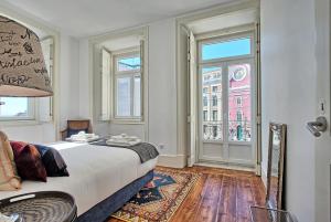 um quarto com uma cama e uma grande janela em MyPlaceLisbon - Luxury Trindade III em Lisboa