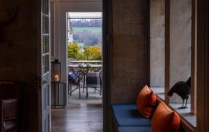 a room with a blue couch and a view of a table at The Painswick in Painswick