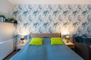 a bedroom with a blue bed with two green pillows at Apartamenty Świnoujście - Wyspiańskiego 34e in Świnoujście