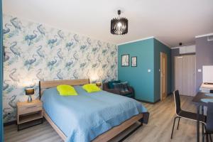 a bedroom with a blue bed and a blue wall at Apartamenty Świnoujście - Wyspiańskiego 34e in Świnoujście