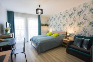 a bedroom with a bed and a table and a couch at Apartamenty Świnoujście - Wyspiańskiego 34e in Świnoujście