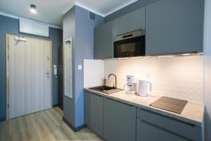 a kitchen with blue walls and a counter with a sink at Apartamenty Świnoujście - Wyspiańskiego 34e in Świnoujście