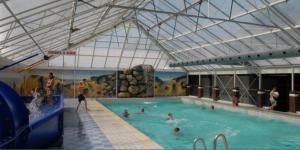 a large indoor swimming pool with people in it at Charming year round chalet in awesome vacation park on a great lake in Suameer
