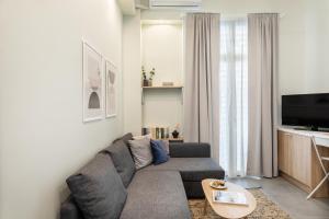 a living room with a couch and a tv at Urban loft II in Thessaloniki