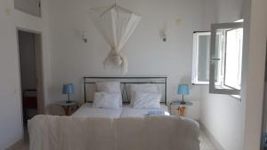 ein Schlafzimmer mit einem Bett mit weißer Bettwäsche und zwei Lampen in der Unterkunft Água Rocha in Serra de Mangues