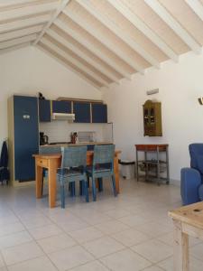 a kitchen with a table and chairs in a room at Água Rocha in Serra de Mangues