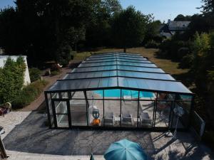 een glazen huis met een zwembad erin bij L'Armoric Hôtel in Bénodet