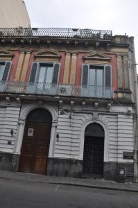 un edificio con 2 puertas y un balcón en una calle en Appartamenti Villa Bellini, en Catania