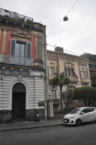 un coche blanco estacionado frente a un edificio en Appartamenti Villa Bellini, en Catania