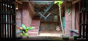 日惹加多加多住宿加早餐民宿的砖墙,有钟和吉他