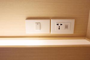 un interruptor de luz en una pared de madera en una habitación en About A Bed Hostel Chiangmai, en Chiang Mai
