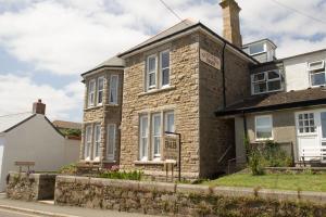 a brick house with a sign in front of it at Glenleigh Bed and Breakfast in Marazion