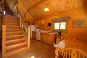 a kitchen and dining room with a staircase in a cabin at Medina Highpoint RV Resort in Medina