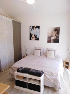 ロクブリューヌ・シュル・アルジャンにあるDIVAの白いベッド1台と壁に2枚の絵が飾られたベッドルーム1室が備わります。