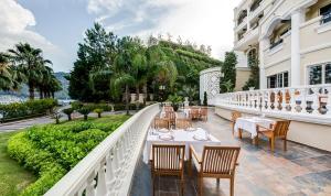 a restaurant with tables and chairs on a balcony at Angel's Marmaris Hotel in Turgut