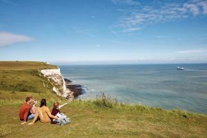 una familia sentada en lo alto de un acantilado con vistas al océano en St. Margaret's Hotel, en Saint Margaretʼs at Cliffe