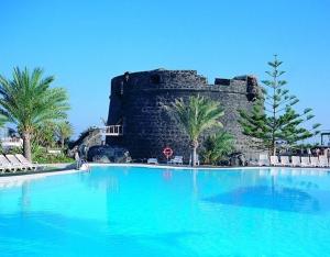 a large swimming pool in front of a castle at RESIDENCE NUEVO HORIZONTE in Costa de Antigua