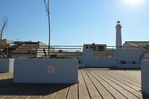 a rooftop deck with a lighthouse in the background at Sempreverde Atelier B&B in Punta Secca