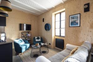 uma sala de estar com um sofá e duas cadeiras em La Hune by Cocoonr em Saint Malo