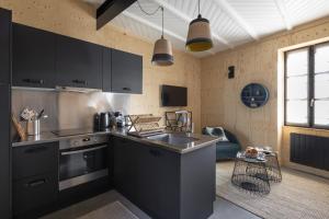 uma cozinha com armários pretos e um lavatório em La Hune by Cocoonr em Saint Malo