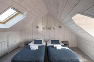 a bedroom with two beds in a attic at La Hune by Cocoonr in Saint Malo