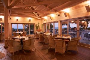 a restaurant with tables and chairs and windows at PortoBay Falesia in Albufeira