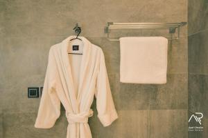 Aspar Resorts في الرياض: رداء أبيض معلق على رف المناشف في الحمام