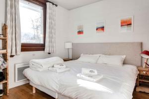 シャモニー・モンブランにあるLe Paradis 27 apartment - Chamonix All Yearのベッドルーム1室(白いベッド1台、タオル2枚付)
