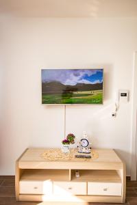 une table avec une horloge et une photo sur le mur dans l'établissement Celebrity Style Lux Apartment, à Bar