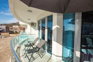 two chairs on a balcony with an umbrella at Celebrity Style Lux Apartment in Bar