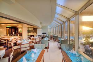 a restaurant with blue tables and chairs and windows at Majestic City Retreat Hotel in Dubai