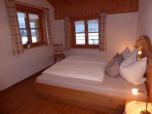 - une chambre avec un lit doté de draps et d'oreillers blancs dans l'établissement Ferienwohnung Bolsterlang, à Bolsterlang