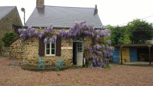 een huis met een krans van paarse bloemen erop bij Gite Bleu in MÃ©nil-Vin